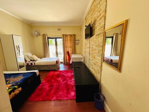 a living room with a couch and a bed and a mirror at Executive Accommodation Bellville 1 in Bellville