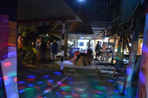 a group of people standing outside of a building at night at La Brújula Hostel in La Paloma
