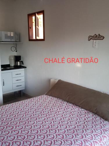 a bedroom with a bed and a sign on the wall at Chalés Mimar Lumiar Suítes individuais in Lumiar