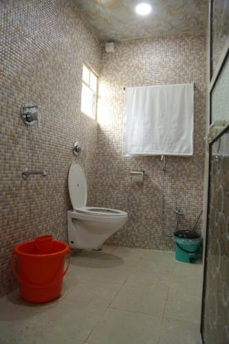 a bathroom with a toilet and a shower and a window at Dream House in Satara