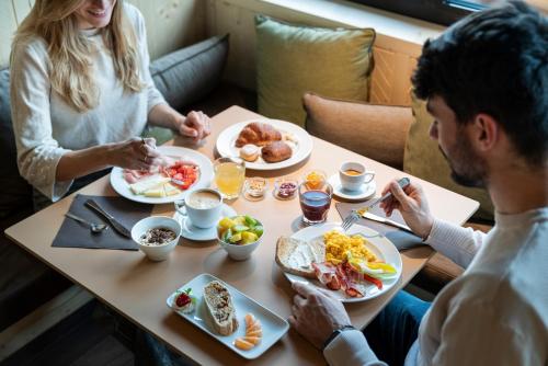 a group of people sitting at a table eating breakfast at Ambiez Residencehotel in Madonna di Campiglio