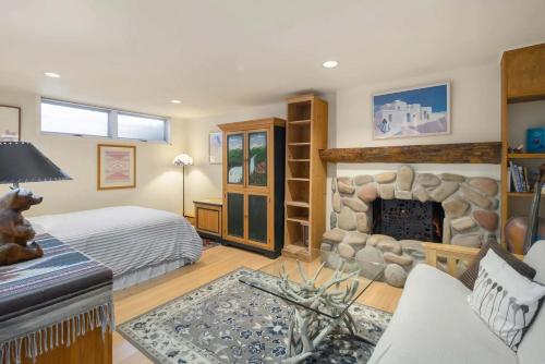 a bedroom with a bed and a stone fireplace at Casa Connable by Snowmass Vacations in Aspen