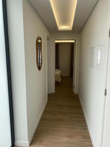 a hallway with white walls and a mirror on the wall at Casa Flor d`Angra in Angra do Heroísmo