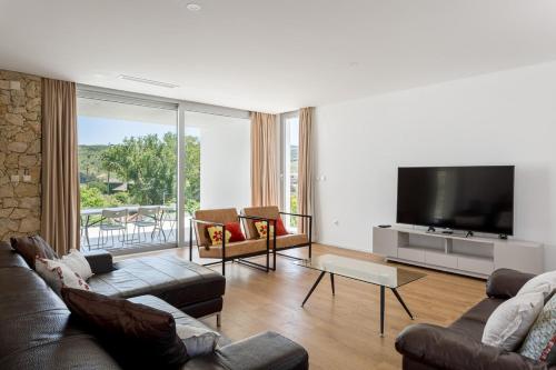 a living room with a couch and a flat screen tv at GuestReady - Exquisite villa w/ Pool & Parking in Pancas