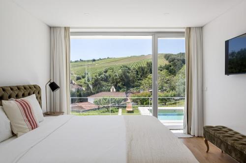 a bedroom with a large white bed and a large window at GuestReady - Exquisite villa w/ Pool & Parking in Pancas
