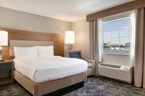 a hotel room with a bed and a window at Candlewood Suites Frederick by IHG in Frederick
