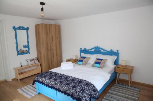 a bedroom with a blue and white bed and a mirror at Casa Ivana Jurilovca in Jurilovca