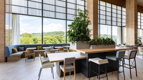 a lobby with tables and chairs and large windows at ANA Holiday Inn Iwate Kitakami by IHG in Kitakami