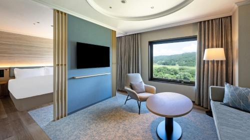 a hotel room with a bed and a table and a chair at ANA Holiday Inn Iwate Kitakami by IHG in Kitakami