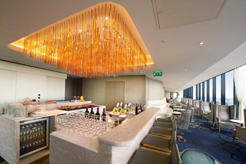 a restaurant with a long bar with wine bottles at The Manchester Deansgate Hotel, by IHG in Manchester