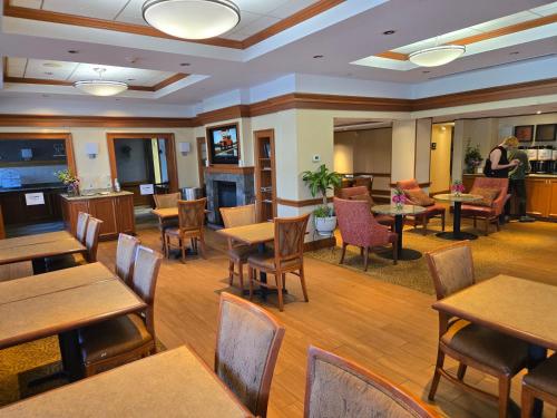 a restaurant with wooden tables and chairs and people at Long Creek Hotel in South Portland