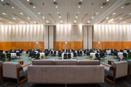 a room with couches and tables and chairs at The Manchester Deansgate Hotel, by IHG in Manchester