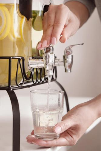 a person is pouring water into a glass at Garner Hotel Paducah West in Paducah