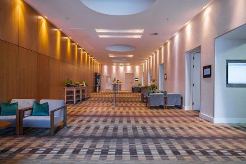 a hallway of a hospital with chairs and a tv at The Manchester Deansgate Hotel, by IHG in Manchester