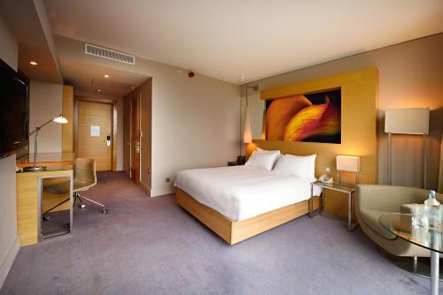 a hotel room with a bed and a desk and a television at The Manchester Deansgate Hotel, by IHG in Manchester