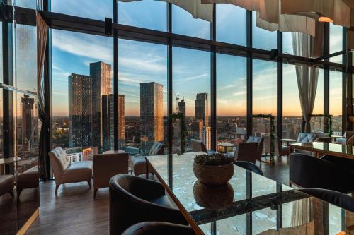 a restaurant with a view of a city skyline at The Manchester Deansgate Hotel, by IHG in Manchester