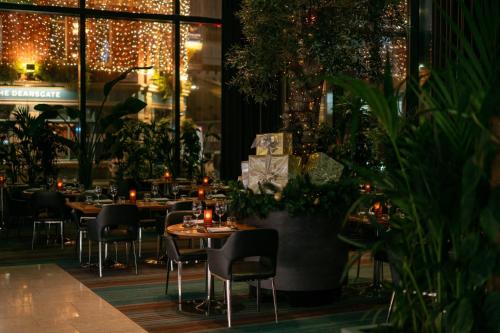 a restaurant with tables and chairs and christmas lights at The Manchester Deansgate Hotel, by IHG in Manchester