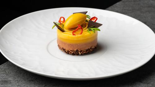 a dessert on a white plate on a table at The Manchester Deansgate Hotel, by IHG in Manchester
