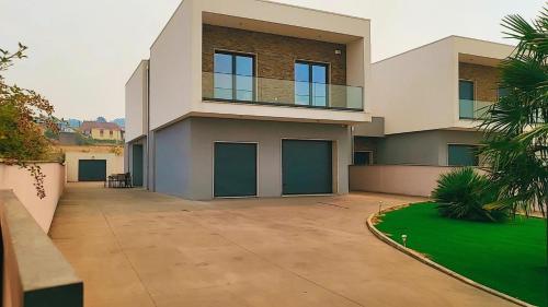 a large house with green doors and a driveway at Villa Machado Chaves in Vila Nova da Veiga