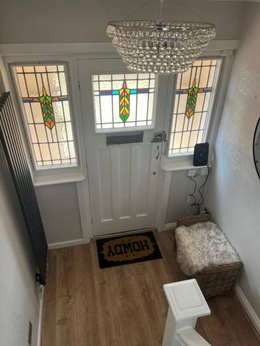 a living room with three windows and a chandelier at 4 BRD House, with Double Parking in Earley
