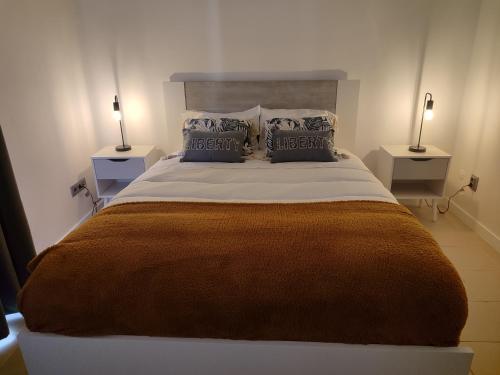 a bedroom with a large bed with two night stands at Calço da Figueira in Horta