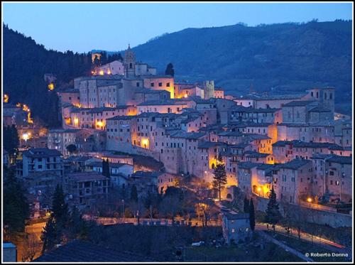 a group of buildings in a city at night at Libera Mente in Fabriano