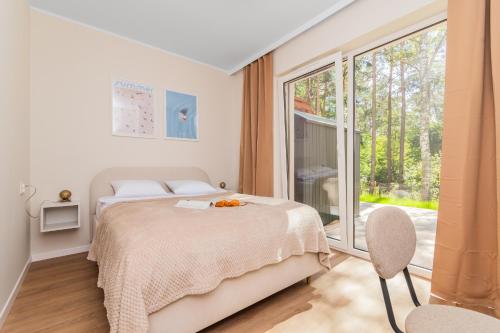 a bedroom with a bed and a large window at APARTAMENTY MIERZEJA - STEGNA PARK II, MEDIUM, 500 m od plaży, Bezpłatny Meleks in Stegna