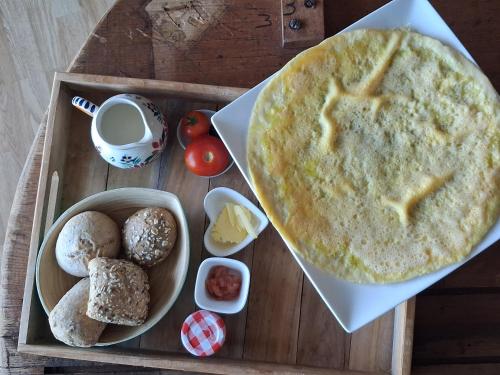 a wooden tray with a plate of food and bread at Les mésanges bleu in Malmedy