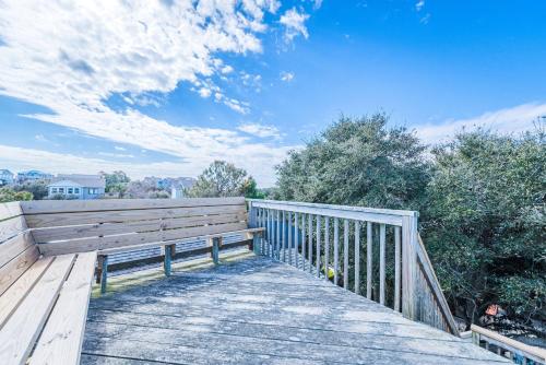 a wooden walkway with a bench on a fence at Coker Cabana in Sanderling