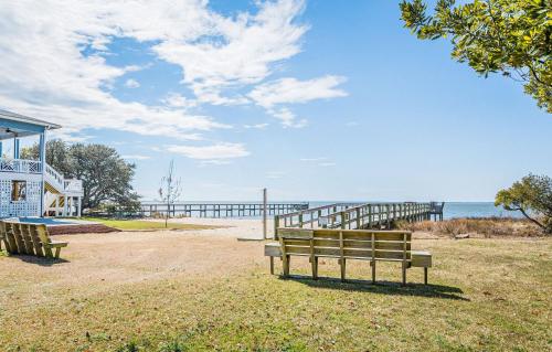 two benches sitting on the grass near the ocean at Coker Cabana in Sanderling