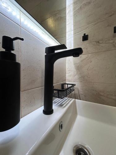 a bathroom sink with a black faucet on it at Párty penzion Dolany in Čkyně