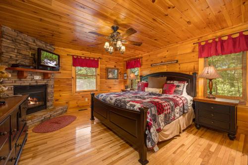 a bedroom with a bed and a fireplace in a log cabin at Moonbeams & Cabin Dreams by American Patriot Getaways in Little Cove