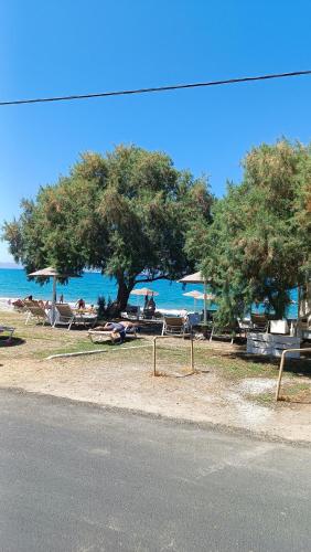 a group of people sitting on the beach near the water at Relax Private Pool House in Maleme