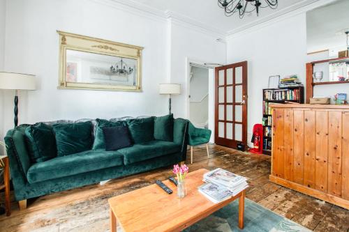 a green couch in a living room with a coffee table at OYO The Lodge Bournemouth in Bournemouth