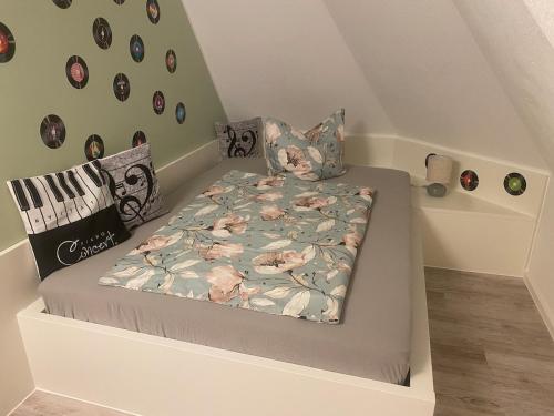 a small bed with a comforter and pillows on it at Ferienwohnung Maria mit Elbblick in Coswig