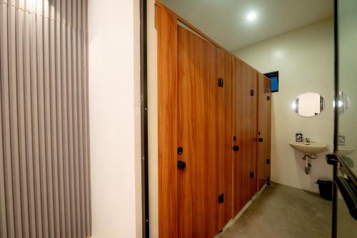 a bathroom with a wooden door and a sink at Cozypod Rentals in Sagcahan