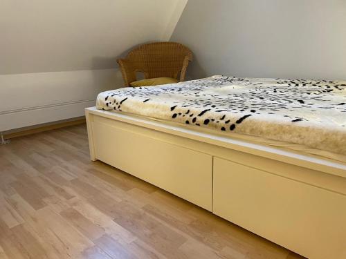 a bed in a room with a chair next to it at Ferienwohnung Maria mit Elbblick in Coswig