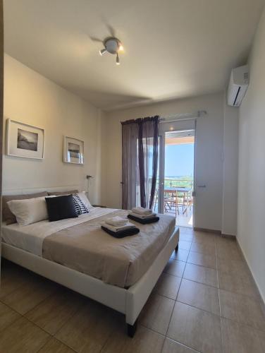 a bedroom with a large bed and a balcony at Relax Private Pool House in Maleme