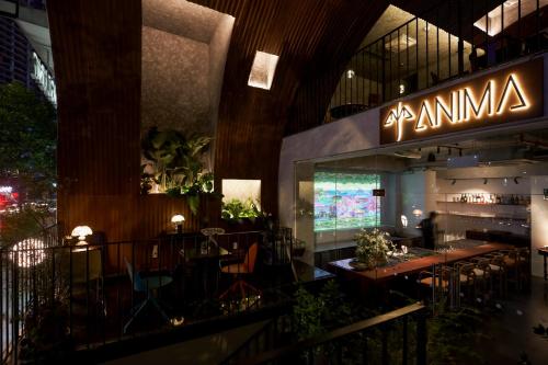 ホーチミン・シティにあるAnima Saigon Boutique - Vietnamese Contemporary Art Hotelの建物の中にテーブルと椅子があるレストラン