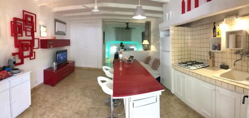 a kitchen with white cabinets and a red counter top at 89 Le Grand Pin in Sainte-Maxime