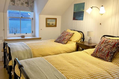 a bedroom with two beds and a window at Old Schoolhouse in Inveraray