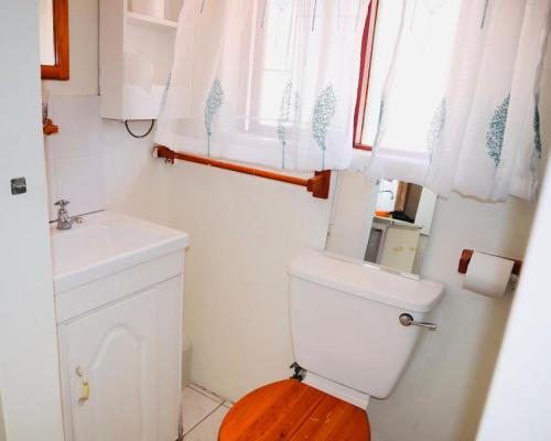a bathroom with a toilet and a sink and a window at Executive Accommodation Bellville 1 in Bellville