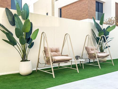 two swinging chairs on a lawn with plants at Luxurious Villa on Saadiyat for Large Groups and Families in Abu Dhabi