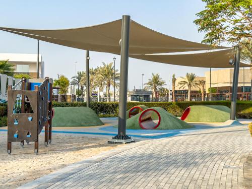 a large tan canopy over a playground with slides at Luxurious Villa on Saadiyat for Large Groups and Families in Abu Dhabi