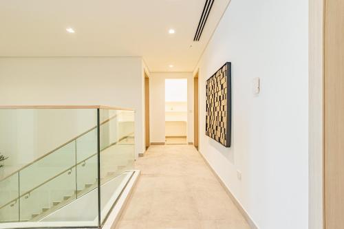 a hallway of a house with glass railings at Luxurious Villa on Saadiyat for Large Groups and Families in Abu Dhabi