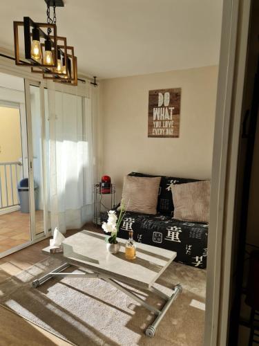 a living room with a couch and a table at Apartment with pool included in Agde