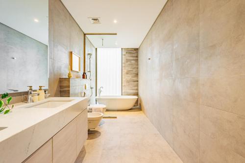 a bathroom with a tub and a toilet and a sink at Luxurious Villa on Saadiyat for Large Groups and Families in Abu Dhabi