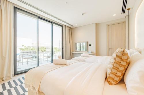 two beds in a room with a large window at Luxurious Villa on Saadiyat for Large Groups and Families in Abu Dhabi