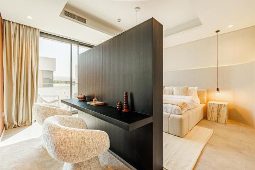 a bedroom with a bed and a desk and two chairs at Luxurious Villa on Saadiyat for Large Groups and Families in Abu Dhabi