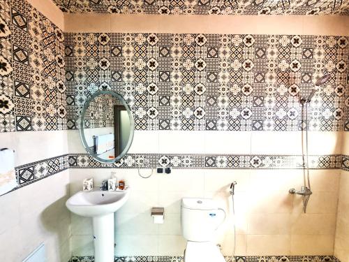 a bathroom with a sink and a toilet and a mirror at Villa des étoiles Groupes in Ourika
